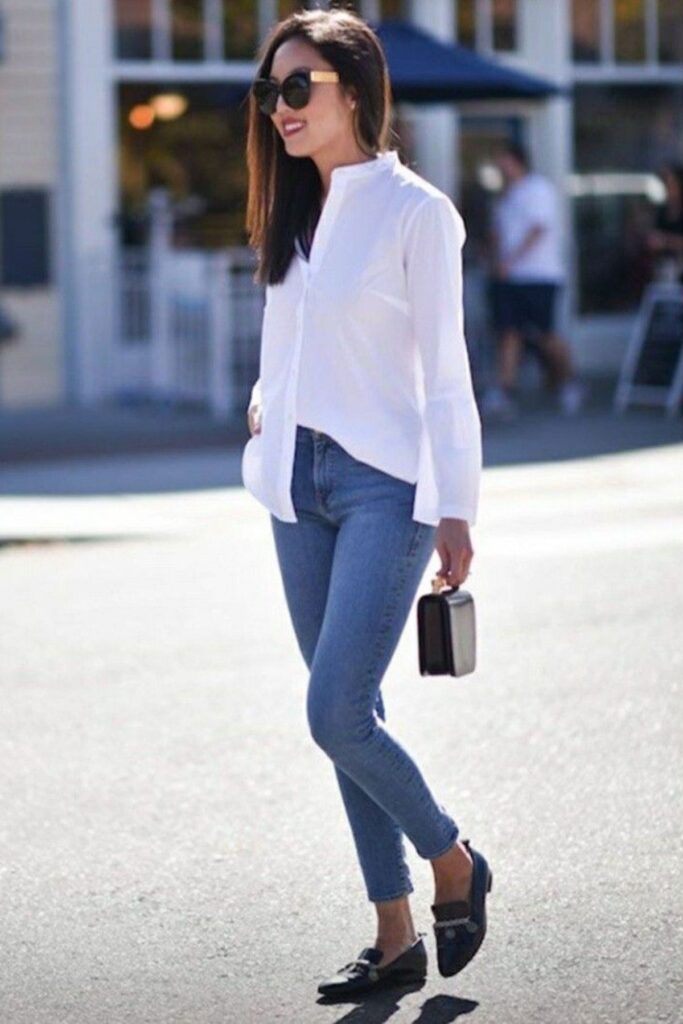 A Petite Woman Wearing A Black Skinny Jeans With a White Button Down and Loafers