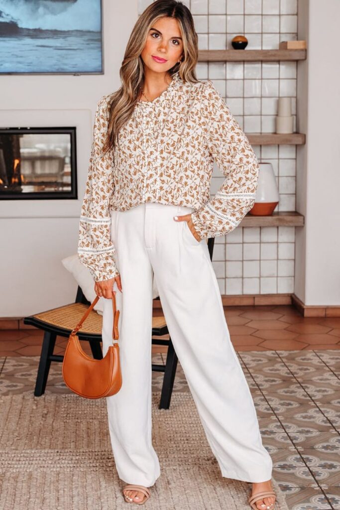 A Petite Woman Wearing A Printed Blouse With Neutral Trousers