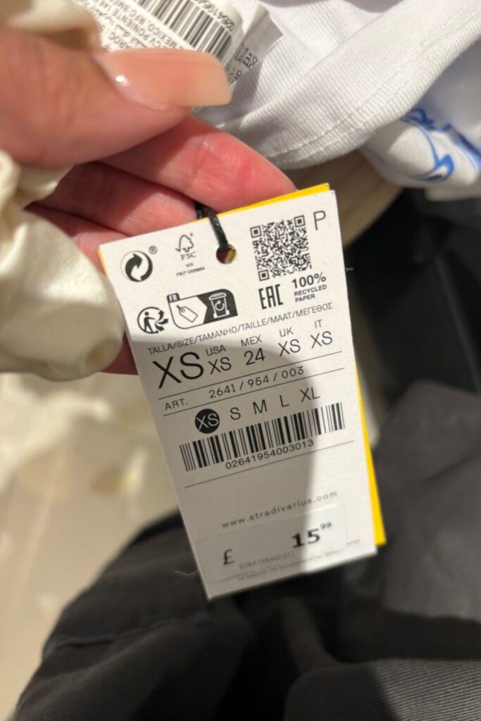 a petite lady looking at a cloth number tag
